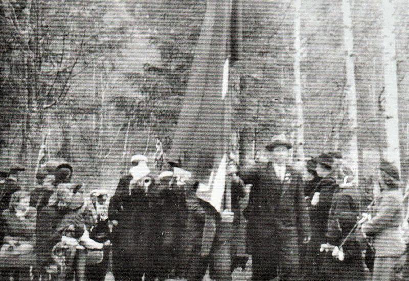 Formann i festkomiteen, Tidemann Ruud, bærer flagget, og til høyre ser vi Ola Gran, som holder i snora.